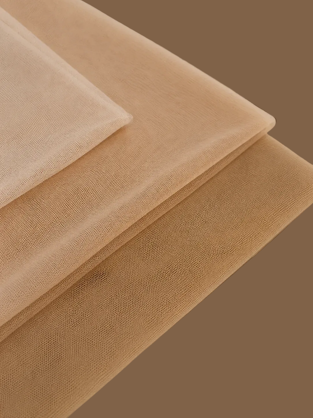 Three overlapping sheer mesh fabric sheets in nude shades of beige, tan, and light brown, displayed on a matching neutral background.